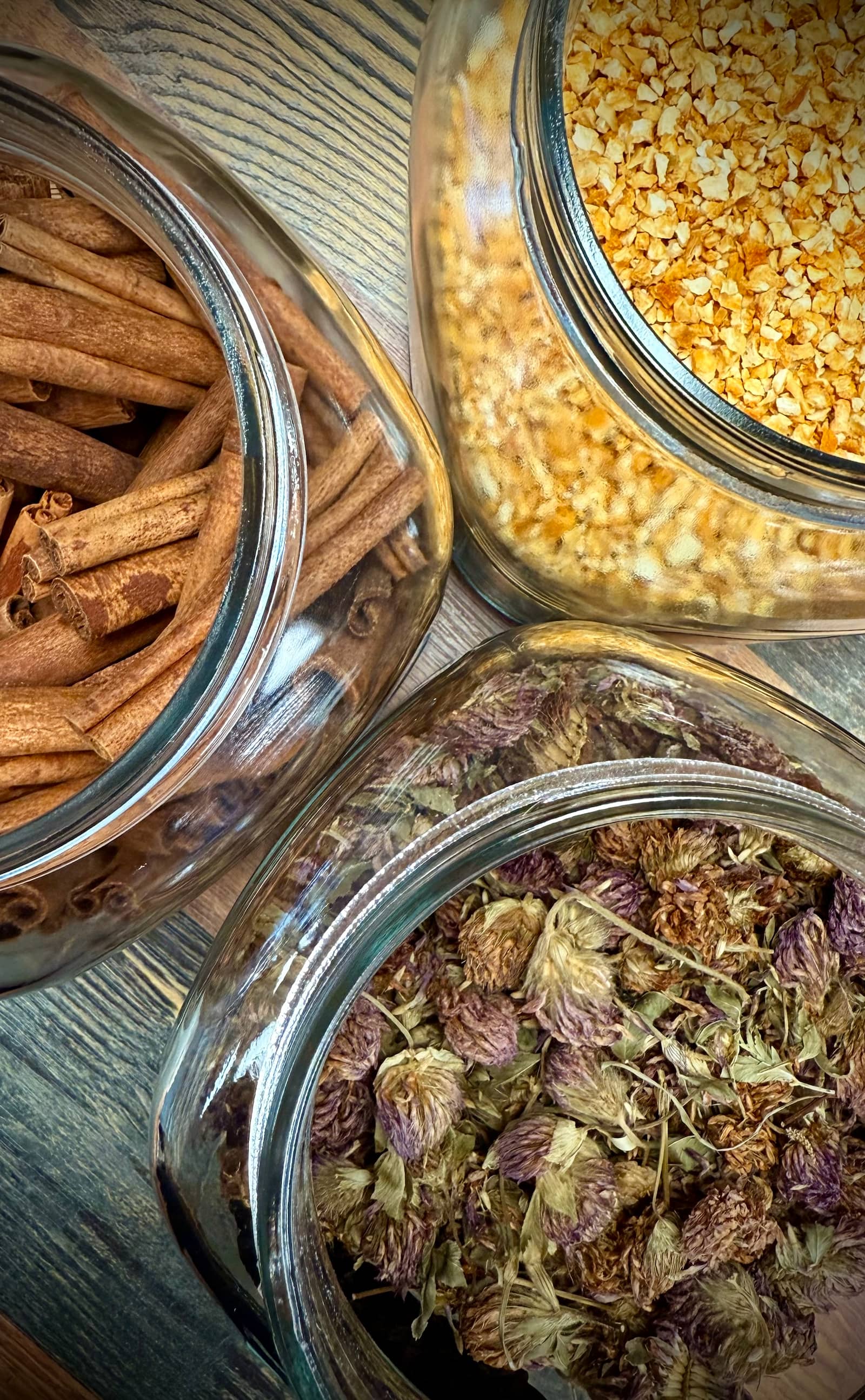 Glass jars of organic spices and herbs on a shelf at Roosters Health Store